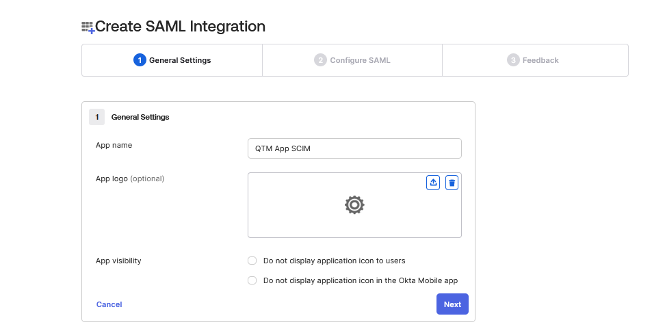 Enter App Name in SAML Integration Setup Okta Create SAML Integration screen displaying the General Settings step. The user enters “QTM App SCIM” as the app name. Options are available to upload an app logo and control app visibility in user dashboards or the Okta Mobile app. Navigation buttons for Cancel and Next appear at the bottom.