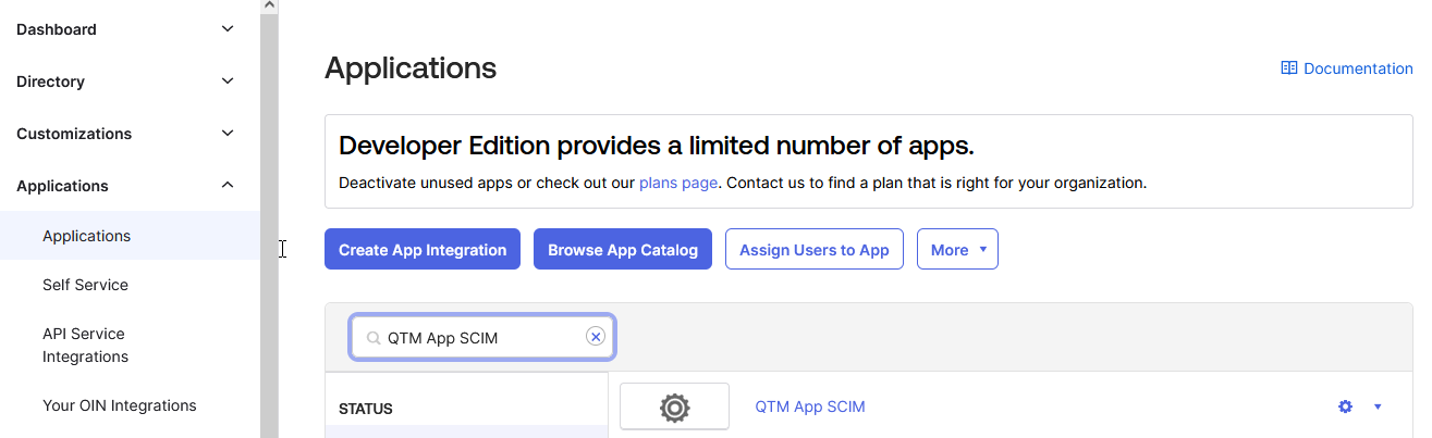 Open QTM App SCIM Integration Okta Applications page showing a search for “QTM App SCIM” within the list of configured applications. The search bar is active, and the QTM App SCIM integration appears in the results under the STATUS section, indicating the app is available for selection.